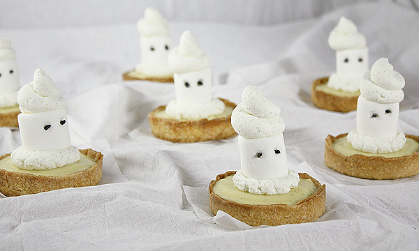 Marshmallow Ghost Tarts randomly displayed on a bunched up linen white sheet.
