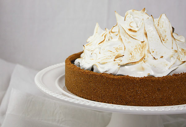 A close up, cropped photo of Baileys S'mores Pie on white cake stand.