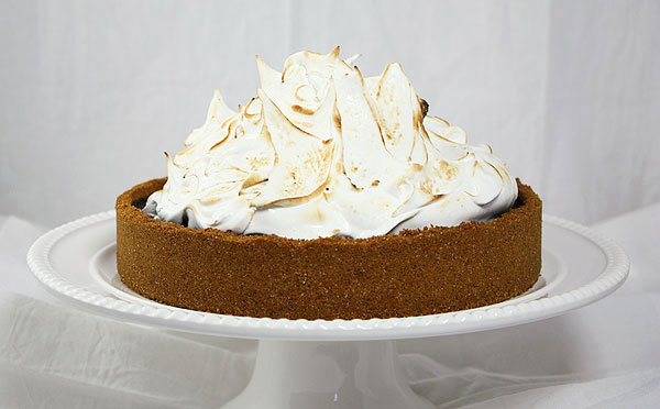 A close up photo of Baileys Smores Pie displayed on white cake stand.