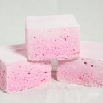 A close up photo of three Boozy Strawberry Marshmallows.