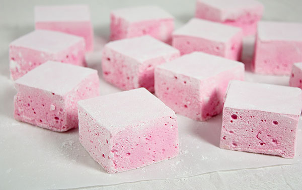 A photo of Strawberry Marshmallows randomly placed on a sheet of baking paper.