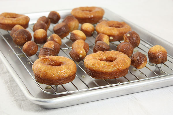 Photo of freshly made Honey Dipped Croissant Doughnuts on wire rack.