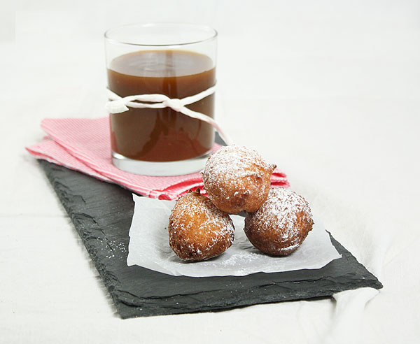 Photo of Butetr-Rum Caramel Sauce in glass displayed with small stack of Ricotta Fritters.