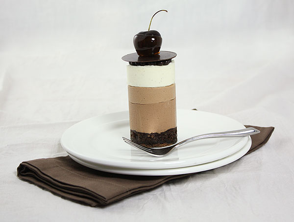 Mini Chocolate Mousse Cake decorated with caramel dipped cherry and chocolate disc.