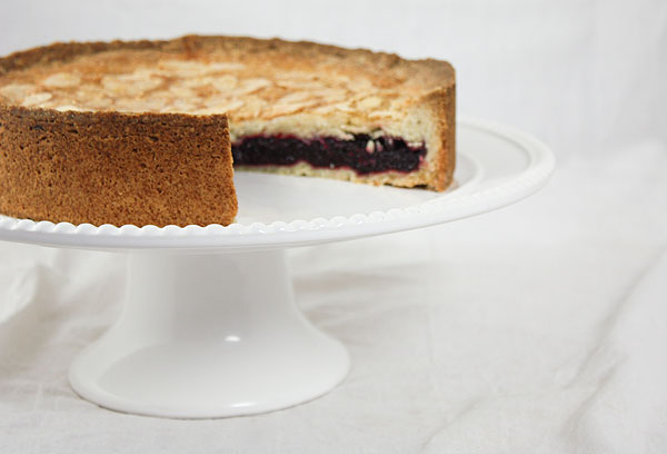 Close up and cropped photo of Blackberry and Almond Coffee Cake with slice removed to expose inside layer of homemade Blackberry Jam.