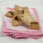 Nutella cookies stacked on white and pink striped cloth napkin lined with parchment paper.