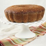 Pear and Walnut Bread displayed on white ruffled edge cake stand.