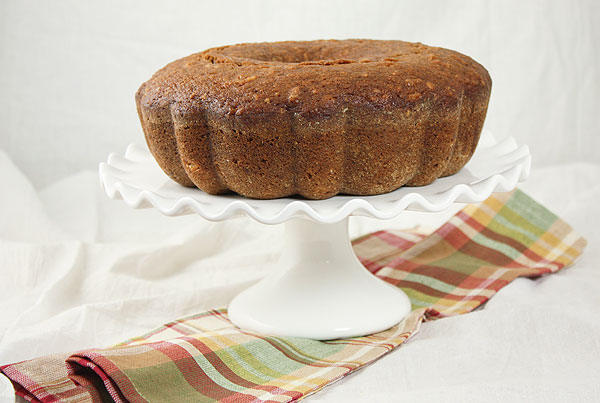Pear and Walnut Bread displayed on white ruffled edge cake stand.