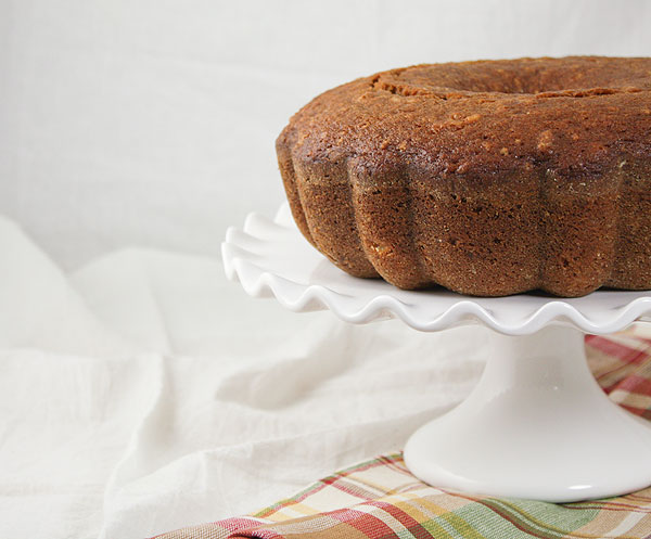 Close up and cropped photo of Pear and Walnut Bread on a white ruffled edge cake stand.