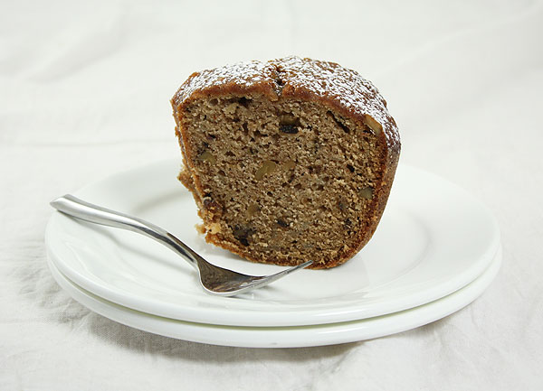 Photo of a slice of Pear and Walnut Quick Bread dusted with confectioners' sugar.